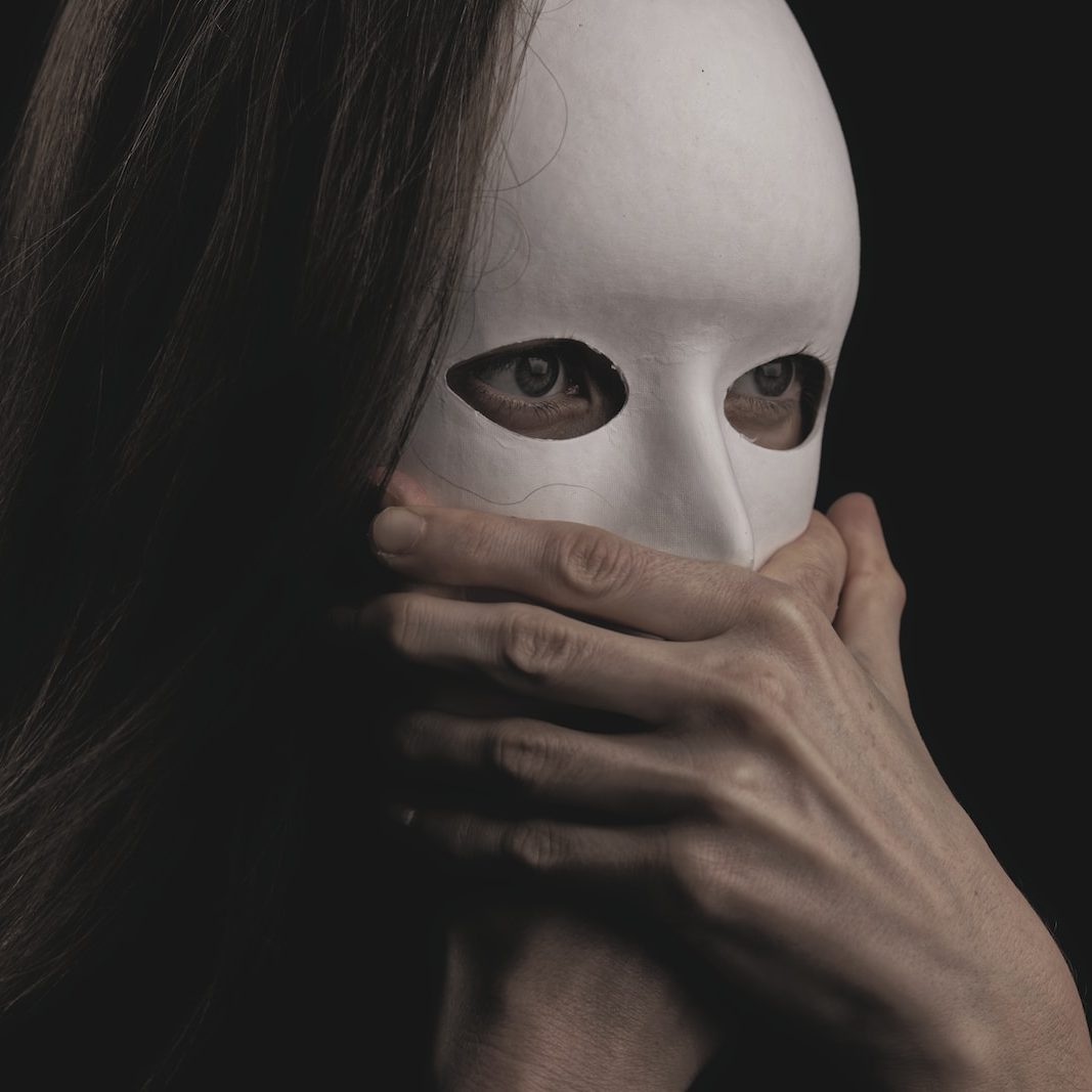 woman covering face with white mask